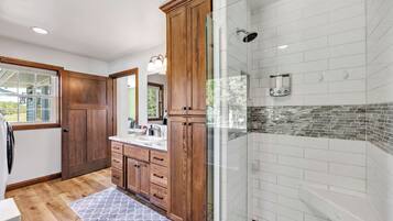 Une cuisine moderne avec des meubles en bois, une cabine de douche en verre et un tapis à motifs.
