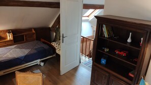 Un dormitorio con cama, una estantería de madera y un tragaluz.