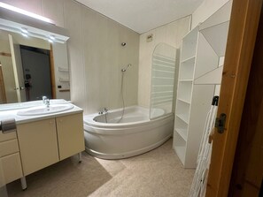 Een moderne badkamer met een vrijstaand bad, een wastafel met spiegel en een douchecabine.