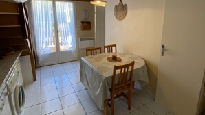 Un espace repas comprenant une table, des chaises et un ventilateur de plafond.