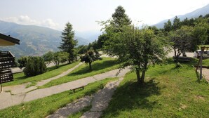 A park with a paved path, benches, and trees. - Cozy Studio Near Ski Slopes, Ideal for Families, Fully Equipped Kitchen (La Plagne Montalbert)