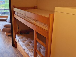 Una cama litera con colchón y estructura de madera.