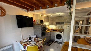 A compact living space with a dining area, kitchen, and a sofa. - Cozy pavilion in Argelès-sur-Mer, near the sea (Argelès-sur-Mer)