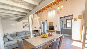 A modern kitchen with a dining area, a fireplace, and a television.