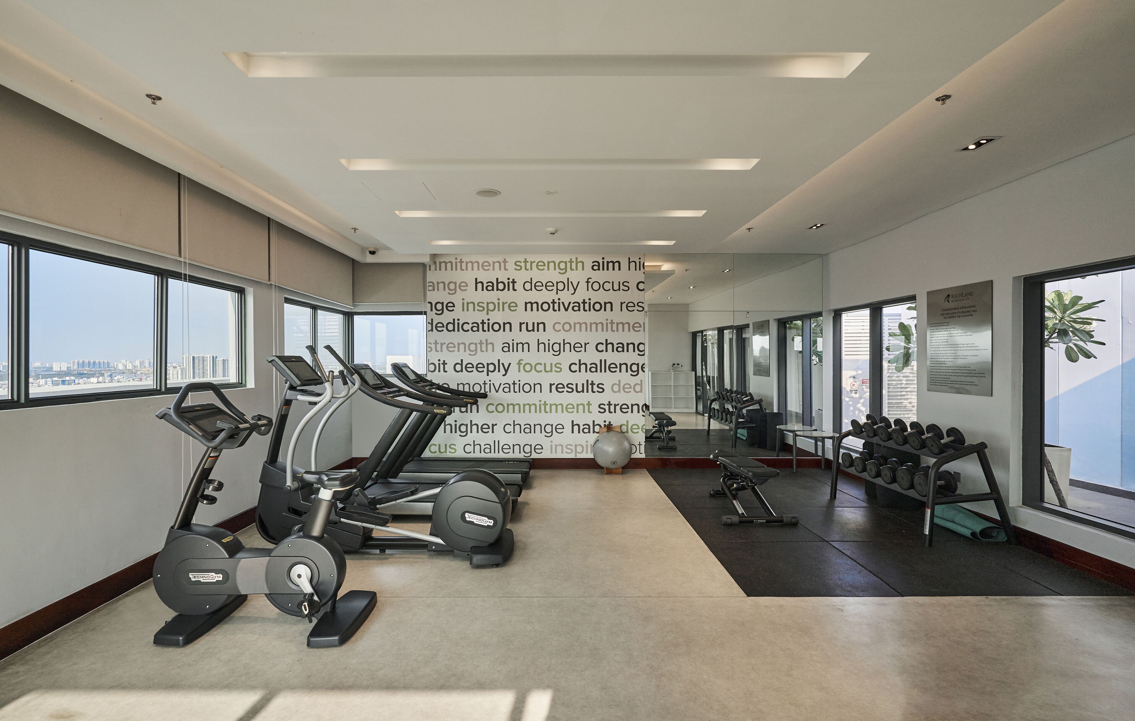 A modern gym with treadmills, dumbbells, and exercise equipment.