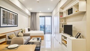 Une chambre d’hôtel moderne équipée d’un lit, d’un canapé, d’une table à manger et d’un téléviseur.
