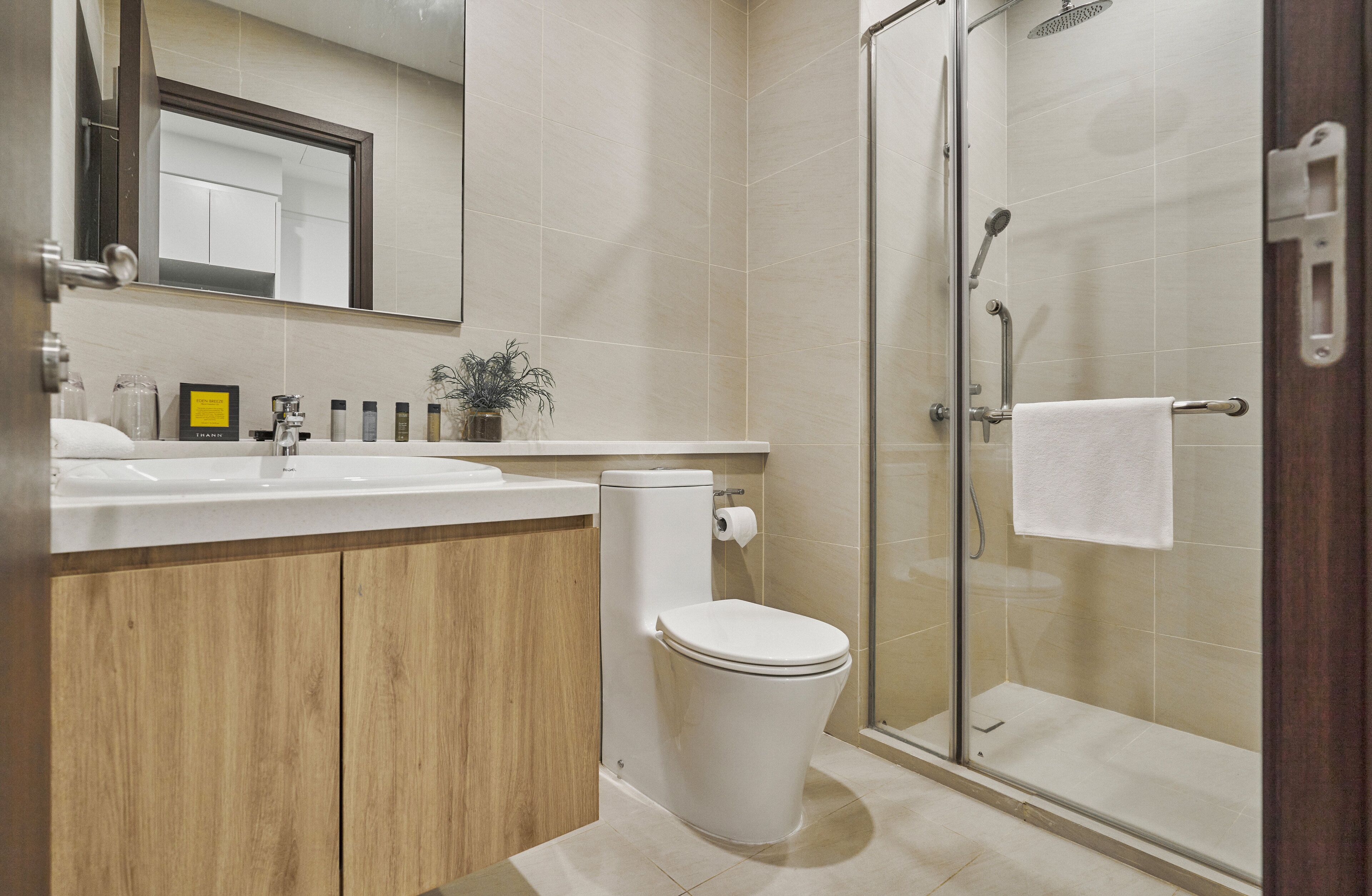 Un baño moderno con inodoro, lavamanos y ducha.