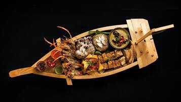 A wooden boat filled with various food items and condiments.
