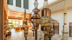 Un vestíbulo amplio con candelabros modernos y un techo alto.