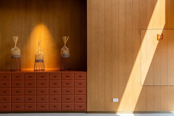Una pared de madera con un estante empotrado que sostiene tres cestas decorativas.