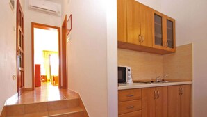 Una cocina con armarios de madera, un microondas y un lavabo.
