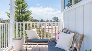 A covered outdoor seating area with wicker furniture and a potted plant. - By the Bay - 4pm check out Sundays* (Rosebud)