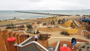 A playground with slides and climbing structures near a beach and pier. - By the Bay - 4pm check out Sundays* (Rosebud)
