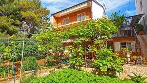 Un immeuble de deux étages doté d’un balcon et d’un espace jardin.
