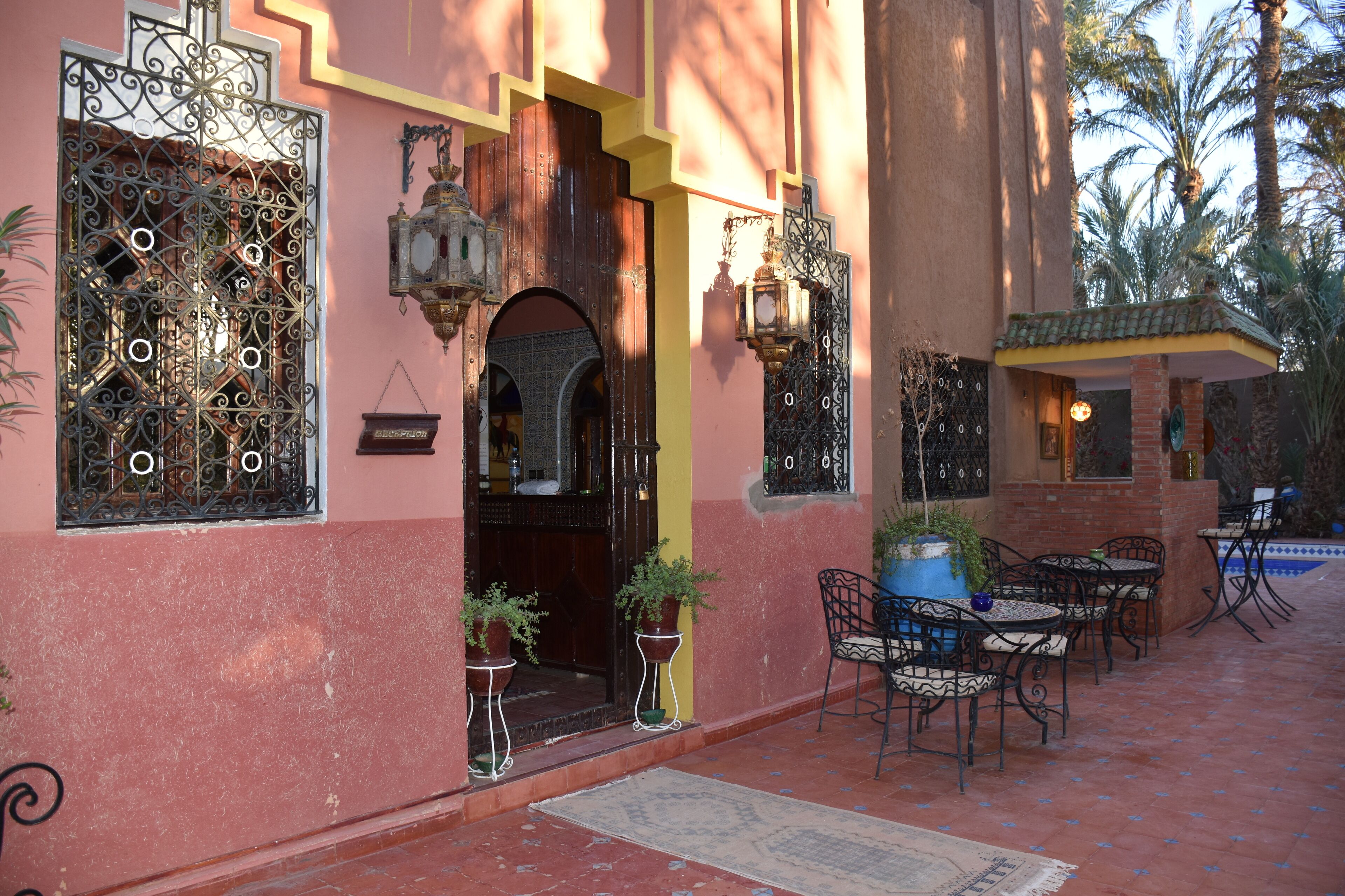 A courtyard with outdoor seating, a wooden door, and decorative ironwork.