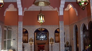 A spacious lobby with intricate tile work, a central fountain, and ornate lighting fixtures. - Riad le Petit Jardin  (Zagora)