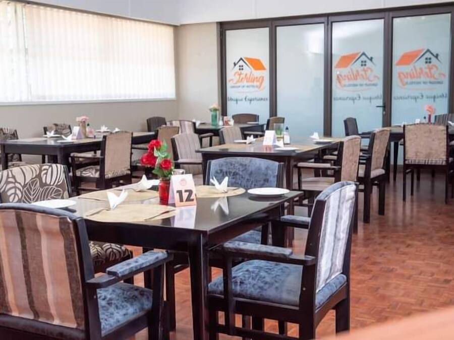Un comedor con mesas y sillas, algunas con centros de mesa florales.