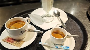A tray with two cups of coffee and a dessert on a table.