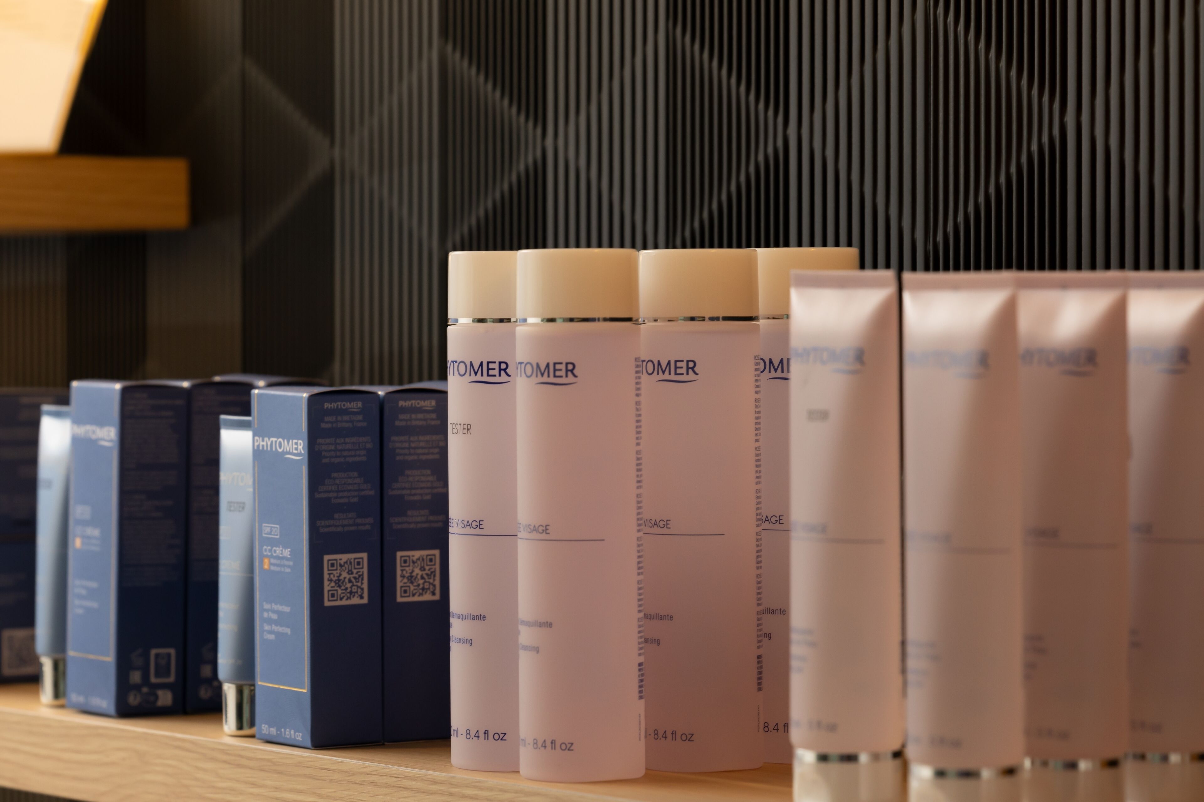 A shelf with various skincare products, including bottles and boxes, arranged in an orderly fashion.