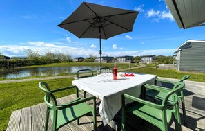 Enjoy a romantic lakeside meal under the shade of a large umbrella.