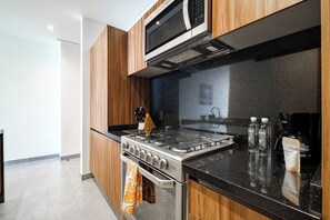 A modern kitchen with a built-in oven, microwave, and gas stove.