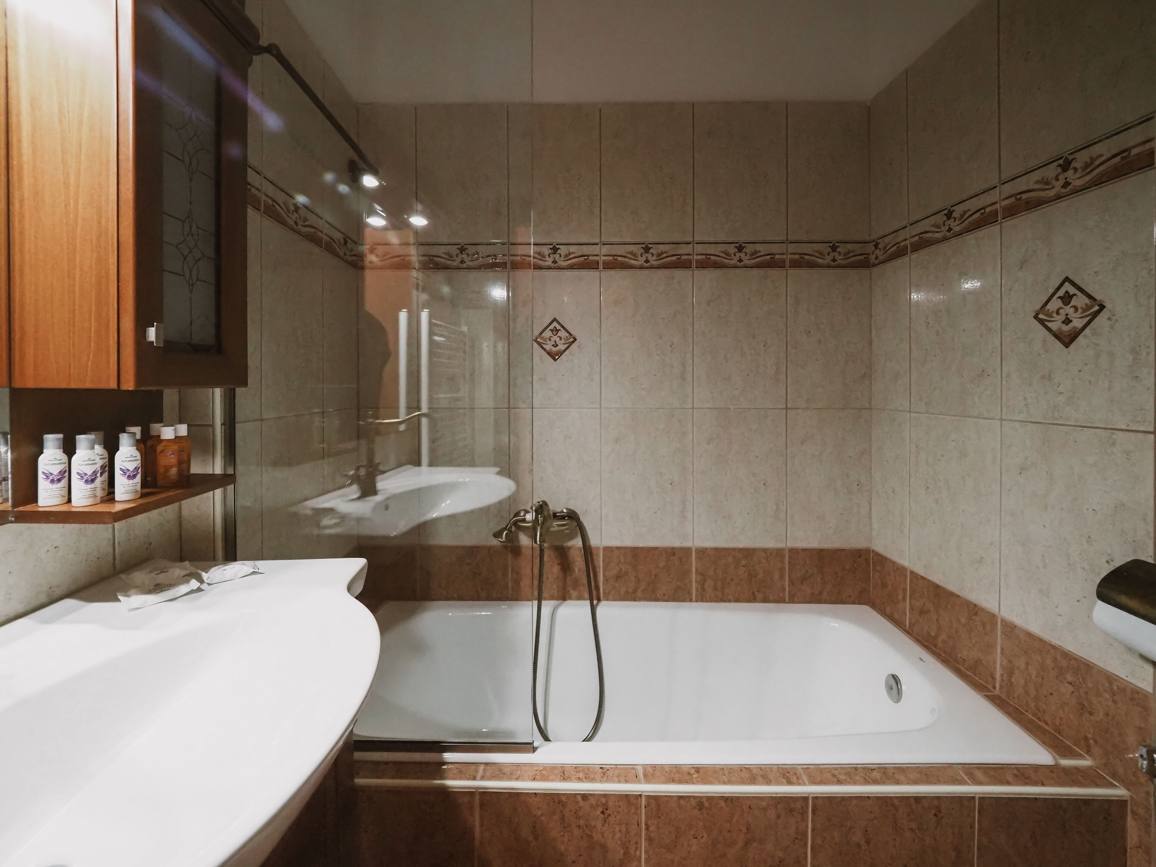 Un baño con bañera, dos lavamanos y tocador con artículos de aseo.