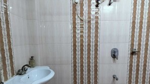 A bathroom with a sink, a shower, and a toilet. - Hotel Rawat (Jodhpur)