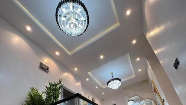 Un intérieur moderne avec une balustrade en verre, un revêtement de sol en marbre et un lustre.