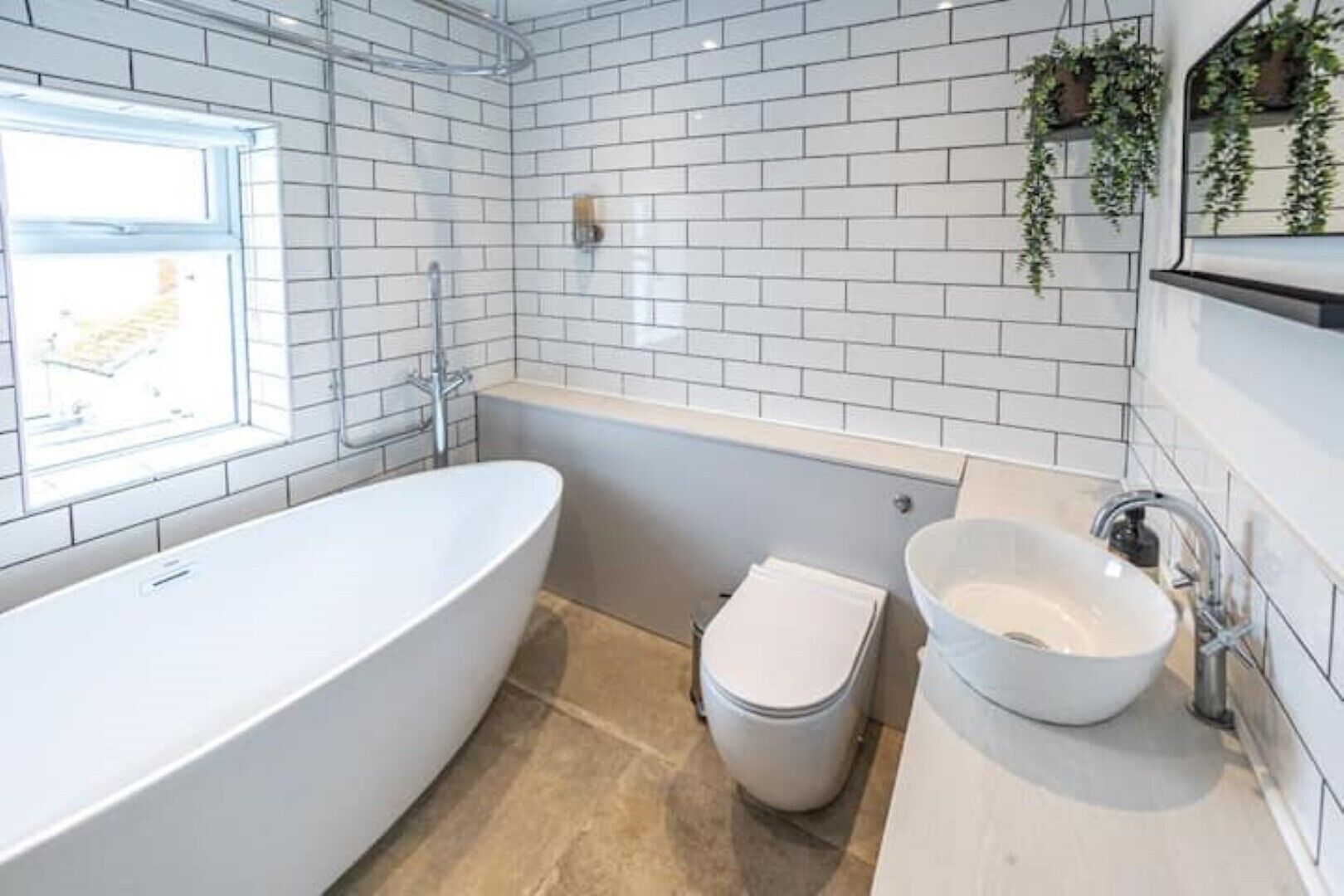 Ein modernes Badezimmer mit freistehender Badewanne, Toilette und Waschbecken.