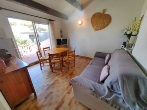 Ein gemütliches Wohnzimmer mit einem Holzesstisch, einer Couch und einer Wanddekoration in Herzform.