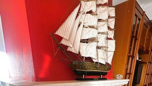 A fireplace with a ship model on top. - Charles Beach House (Ferrel)