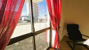 A room with a view of a building and a street. - Charles Beach House (Ferrel)
