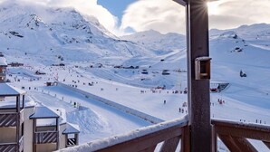 Paisaje nevado de montaña con una estación de esquí, incluyendo telesillas y esquiadores.