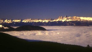 Paisaje montañoso con picos nevados y un valle abajo.
