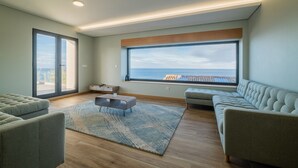 Una sala de estar moderna con un ventanal grande, un sofá, una mesa de centro y una alfombra.