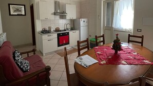 Un espacio habitable compacto con comedor, kitchenette y sofá.