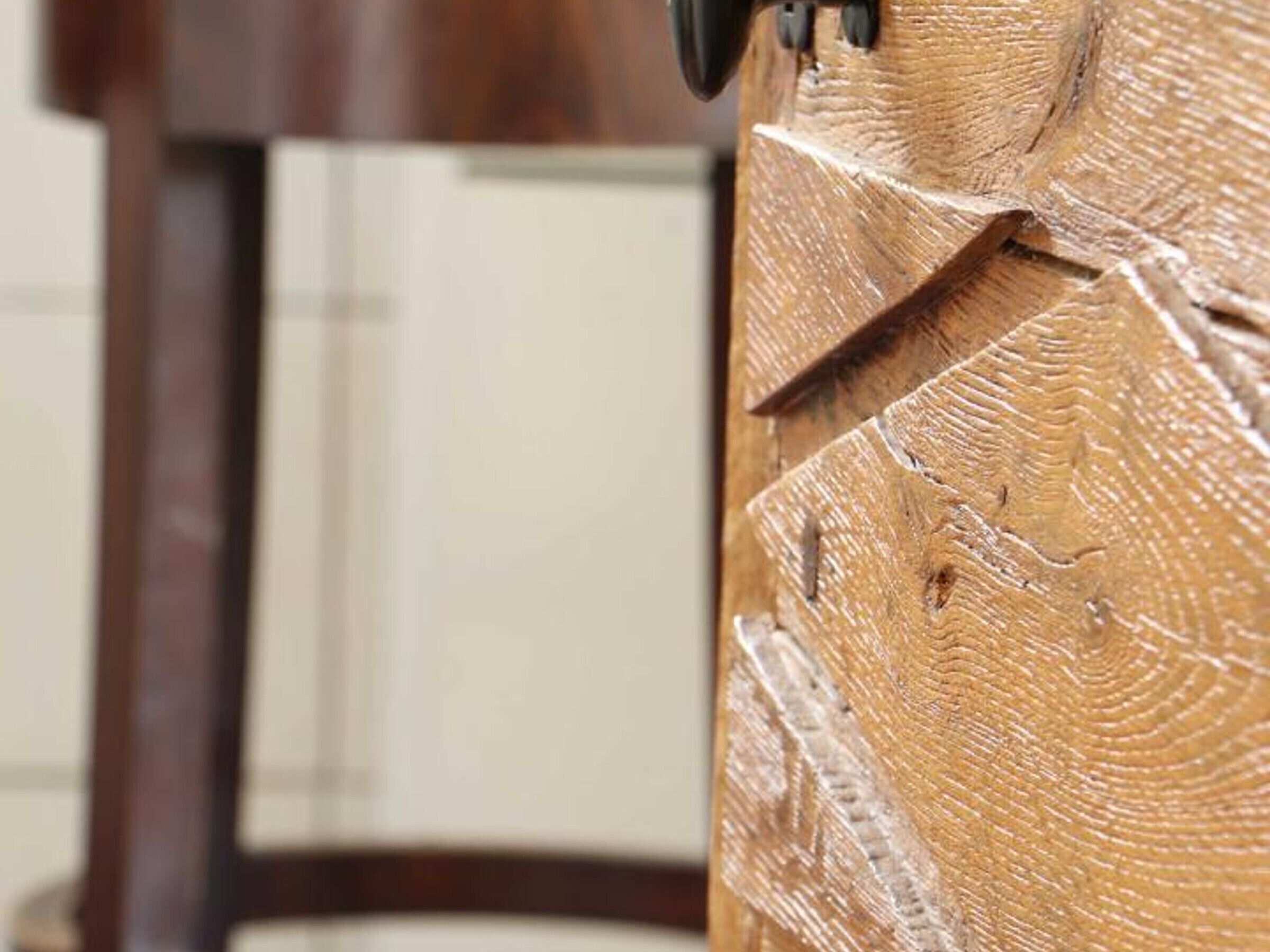 Un gros plan d’une surface en bois présentant un motif texturé, qui pourrait faire partie d’un meuble ou d’un élément décoratif.
