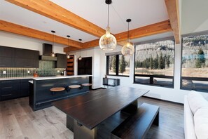 A modern kitchen with dark cabinetry, a central island, and pendant lighting.
