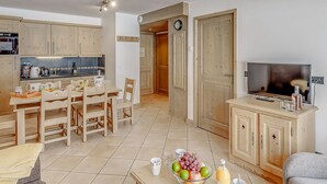 Un espacio habitable compacto con cocina, comedor y televisor.