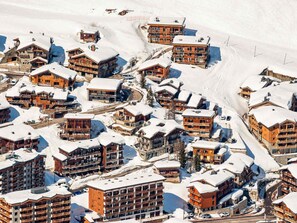 A snow-covered mountain resort with multiple wooden buildings, including lodges and guesthouses.