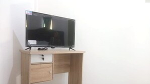 A wooden desk with a television on top, a drawer, and a cable. - Hotel O Ananda Homestay Syariah (Pekanbaru)
