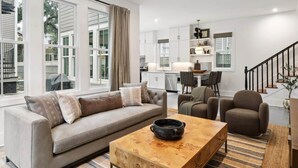 A modern living room with a sofa, armchairs, and a coffee table. - 5BR Victorian Carriage House | Near Forsyth Park (Savannah)
