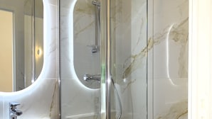 A modern bathroom with a glass-enclosed shower, a vanity with a marble countertop, and a large mirror with an oval frame. - Augustins Fountain Studio AIX Centre Historique à 3 Minutes de Cours Mirabeau (Aix-en-Provence)