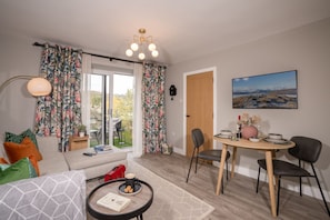 Relax in a comfortable living space with a sofa, dining table, and garden views.
