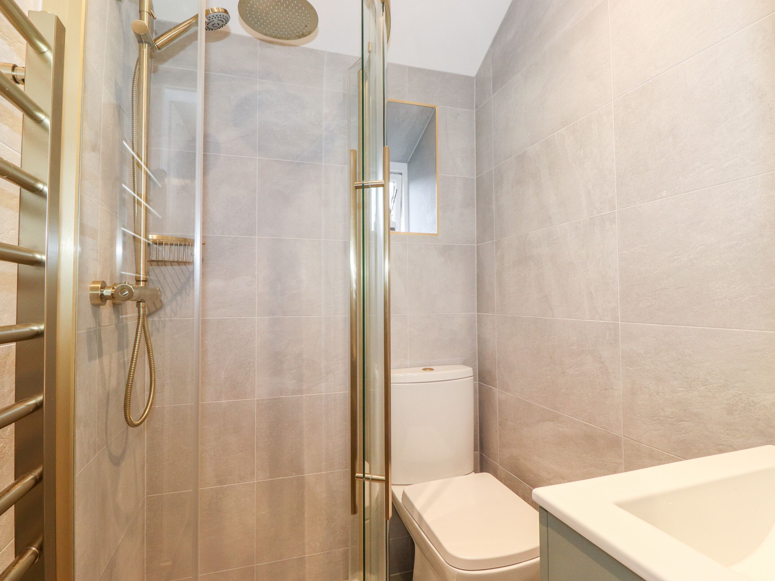 Een moderne badkamer met een douchecabine van glas, een toilet en een bad.