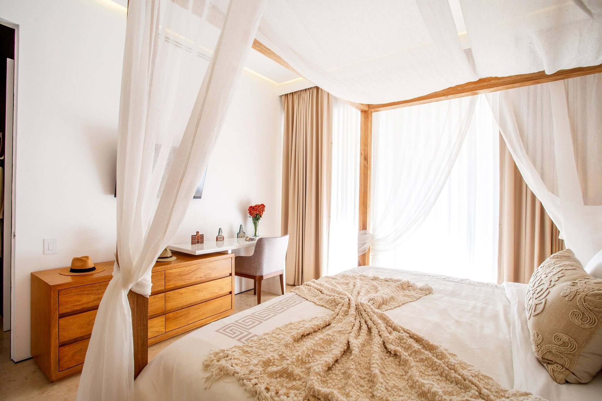 Un dormitorio con una cama, un aparador de madera, un escritorio y una silla.