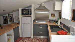 A compact kitchen with a microwave, refrigerator, and a small sink. - Les Deux Tours (Aiguèze)