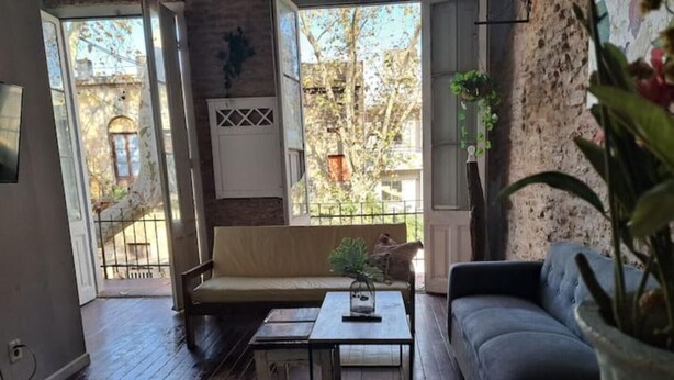 A cozy living room with a sofa, a coffee table, and a plant. - Hermosa Casona Central (Montevideo)