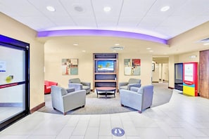 A hotel lobby with seating, a TV, and a ticket counter. - Studio with Hot Tub & Pool Near Universal Studios (Orlando)