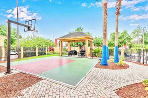 A basketball court with a gazebo, palm trees, and a fenced area. - Studio with Hot Tub & Pool Near Universal Studios (Orlando)